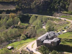 Vue aérienne d'une maison sur une colline avec une route dans l'établissement Casa Grande da Ferreria de Rugando, à Rugando