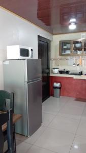 a kitchen with a stainless steel refrigerator and red cabinets at Apartamentos Caimán Tortuguero in Tortuguero +24 photos