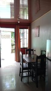 a dining room with a wooden table and chairs at Apartamentos Caimán Tortuguero in Tortuguero
