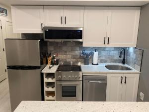 a kitchen with white cabinets and a stove and a sink at Loon Resort Condo-AC, Pool, Hot Tub and Views in Lincoln