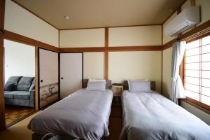 ein kleines Zimmer mit zwei Betten und einer Couch in der Unterkunft Otowa音和 in Kijimadaira