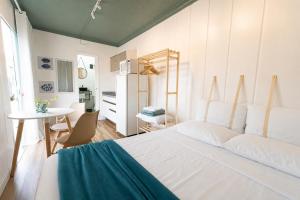 a bedroom with a large white bed and a table at Marco Zero Containers - Próximo à Roda Gigante in Balneário Camboriú
