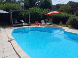 a large blue swimming pool with an umbrella at Chalets avec Terrasse - Capacité 5 Pers. - FR-1-489-288 in Échassières +3 photos