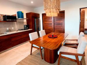 a kitchen with a wooden dining room table and chairs at Mabay in Zihuatanejo