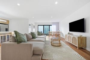a living room with a couch and a flat screen tv at Inverloch Seaside Escape in Inverloch