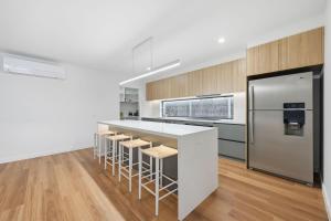 a kitchen with a white counter and a refrigerator at Inverloch Seaside Escape in Inverloch