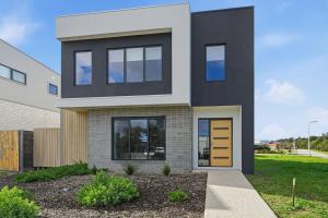 a black and white house with a yellow door at Inverloch Seaside Escape in Inverloch