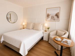 a bedroom with a bed and a table and a chair at Cooks Endeavour Motor Inn - Near beach & Gold Coast Airport in Tweed Heads