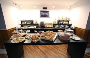a counter with many different types of pastries on it at Hotel San Rocco in Muggia