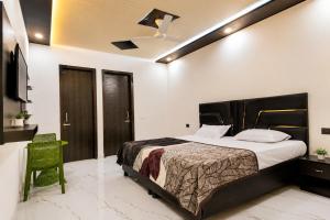 a bedroom with a bed and a green chair at Hotel Brothers Elite Stay in Panchkula