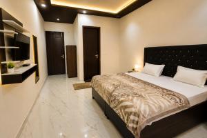 a bedroom with a large bed and a television at Hotel Brothers Elite Stay in Panchkula