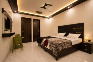 a bedroom with a large bed and a chair at Hotel Brothers Elite Stay in Panchkula