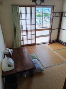 a room with a table and a large window at Guest House Aki in Nichinan +13 photos