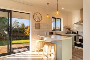 a kitchen with a counter and a clock on the wall at Twizel Cottages in Twizel +41 photos