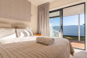 a bedroom with a large bed with a large window at Twizel Cottages in Twizel