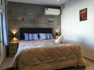 a bedroom with a large bed with blue pillows at Toscana Apartamentos in Progreso