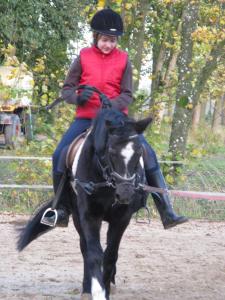 una mujer montando un caballo blanco y negro en Ferienhof Lafrenz en Cuxhaven