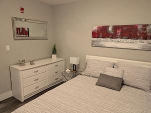 a bedroom with a bed with a dresser and a mirror at Clifton Hill Suite 4401 in Niagara Falls +2 photos