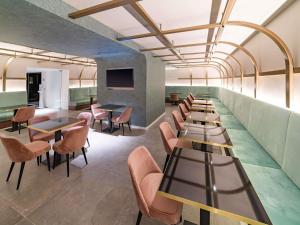 a row of tables and chairs in a restaurant at Mercure St. Julian's Malta in St. Julianʼs