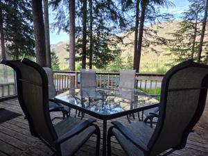 a glass table and chairs on a deck with a view at Hope Sunshine Valley Scenic Mountain View House 3BR 3Bath in Hope