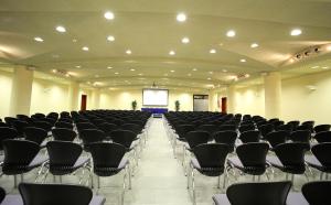 a large room with chairs and a screen at Hotel San Rocco in Muggia