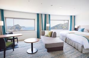 a hotel room with a bed and a couch and a table at Shimoda Tokyu Hotel in Shimoda