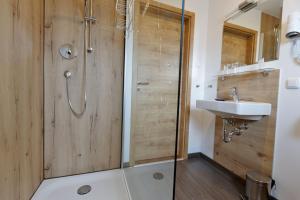 ein Bad mit einer Dusche und einem Waschbecken in der Unterkunft Pension Christina in Vaihingen an der Enz