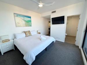 a bedroom with a bed and a flat screen tv at Arizons in South West Rocks +11 photos