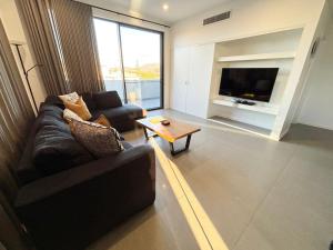 a living room with a couch and a television at Arizons in South West Rocks