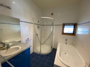 a bathroom with a shower and a tub and a sink at Blue Sky Lodge in Dinner Plain +14 photos