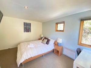 a small bedroom with a bed and a table at Blue Sky Lodge in Dinner Plain
