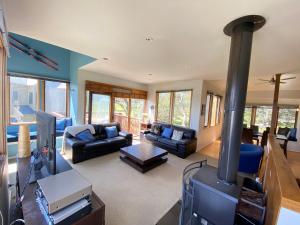 a living room with a fireplace and a stove at Blue Sky Lodge in Dinner Plain