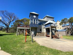 a blue house with a balcony on the front of it at Blue Sky Lodge in Dinner Plain