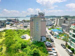 an aerial view of a city with a tall building at Beach Condo Motel in Taean