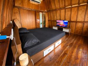 a bedroom with a bed in a wooden room at Wavez Bungalow in Selong Belanak