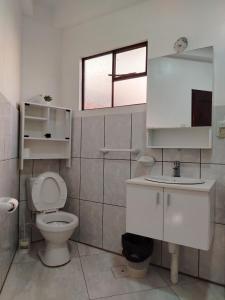 a bathroom with a toilet and a sink and a window at Leo in Copacabana