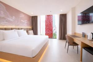 a bedroom with a large white bed and a desk and a desk at Y Hotel Phan Đình Phùng in Can Tho +29 photos