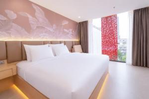 a bedroom with a large white bed and a window at Y Hotel Phan Đình Phùng in Can Tho