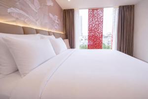 a bedroom with a large white bed and a window at Y Hotel Phan Đình Phùng in Can Tho