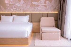 a bedroom with a bed and a chair at Y Hotel Phan Đình Phùng in Can Tho