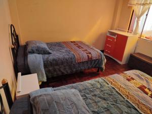 a hotel room with two beds and a dresser at Leo in Copacabana