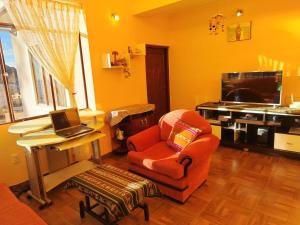 a living room with a chair and a desk with a laptop at Leo in Copacabana