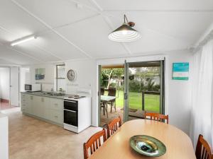 a kitchen and dining room with a table and chairs at River Cottage in Mylestom