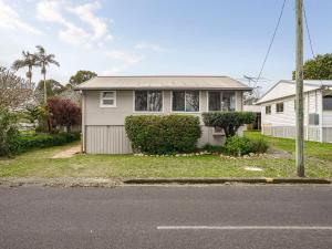 a white house with a tree and a street at River Cottage in Mylestom +10 photos