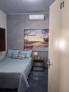 a bedroom with a bed and a painting on the wall at Garden House - Atins in Atins