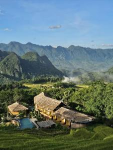a house on a hill with mountains in the background at Pu Luong EcoLuxe Resort & Spa in Pu Luong