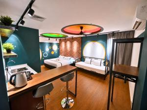 a room with a kitchen and a living room with two beds at Seeds Hotel Chow Kit in Kuala Lumpur