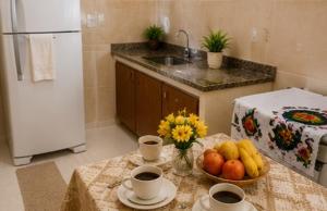 a kitchen with a table with a bowl of fruit at Meu Aconchego - Araruama 2 quartos - Vaga- Wi-Fi in Araruama