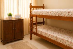 a bedroom with two bunk beds and a wooden cabinet at Meu Aconchego - Araruama 2 quartos - Vaga- Wi-Fi in Araruama