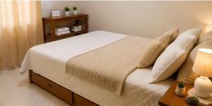 a bedroom with a large bed with pillows at Meu Aconchego - Araruama 2 quartos - Vaga- Wi-Fi in Araruama